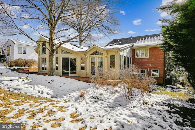 view of snow covered back of property