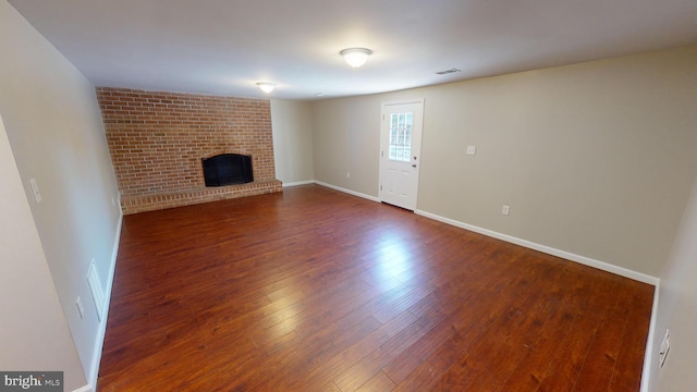 unfurnished living room with dark hardwood / wood-style floors and a fireplace