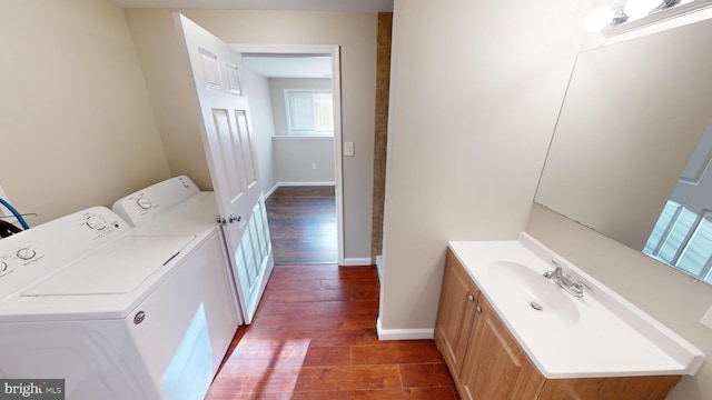 clothes washing area featuring separate washer and dryer, dark hardwood / wood-style flooring, and sink