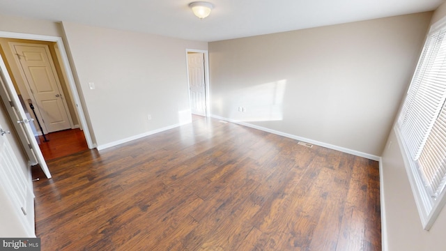 spare room featuring dark wood-type flooring