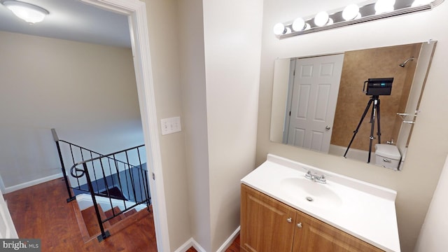 bathroom with a tile shower, wood-type flooring, and vanity