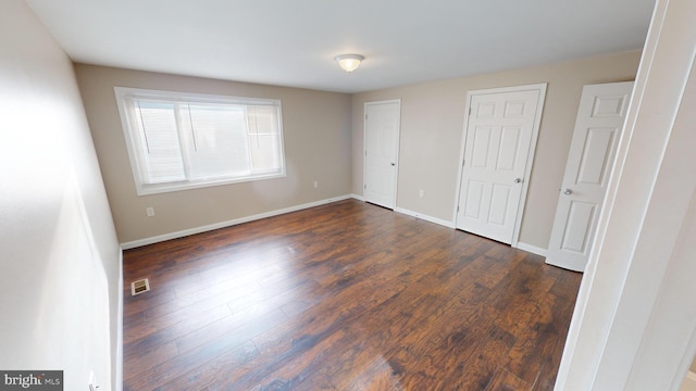 unfurnished bedroom with dark hardwood / wood-style flooring