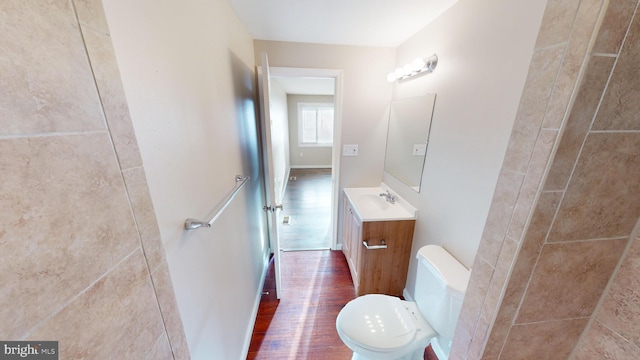 bathroom with toilet, vanity, and hardwood / wood-style flooring