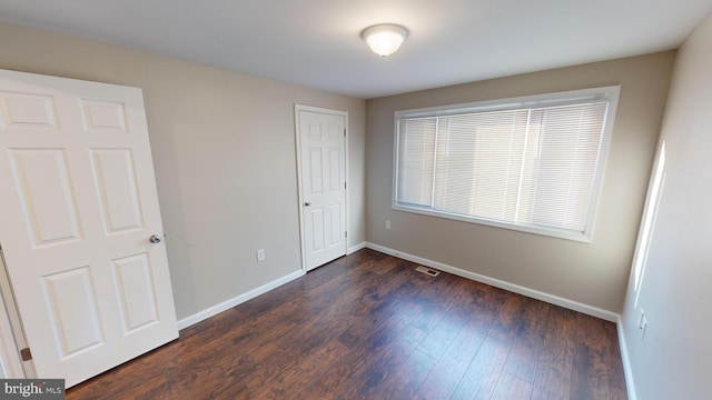 unfurnished bedroom with dark wood-type flooring