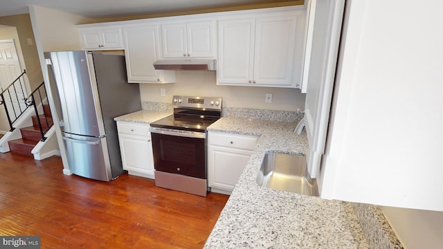 kitchen featuring stainless steel appliances, sink, white cabinetry, light stone countertops, and dark wood-type flooring