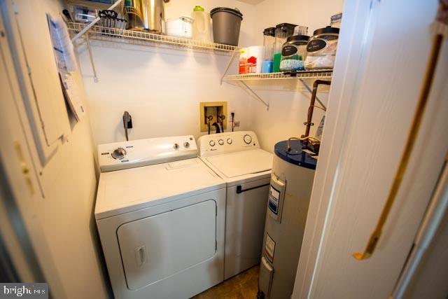 clothes washing area featuring washing machine and dryer and water heater