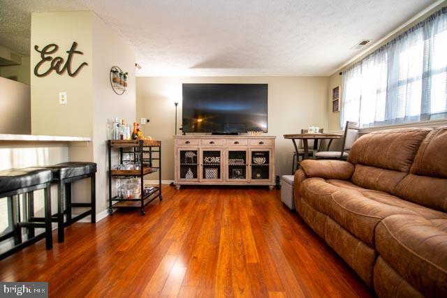 living room featuring a textured ceiling and hardwood / wood-style floors