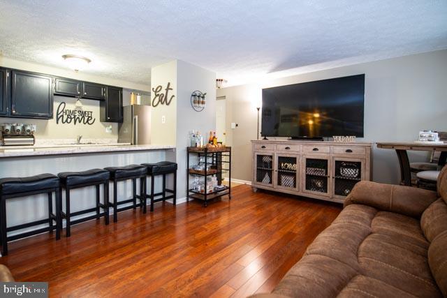 living room featuring a textured ceiling and dark hardwood / wood-style floors