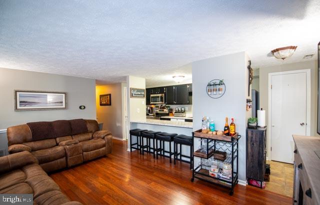 living room featuring a textured ceiling and dark hardwood / wood-style floors