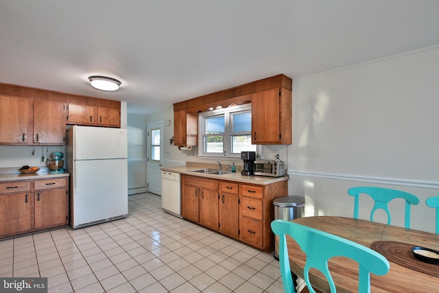 kitchen featuring sink, white appliances, and light tile patterned flooring