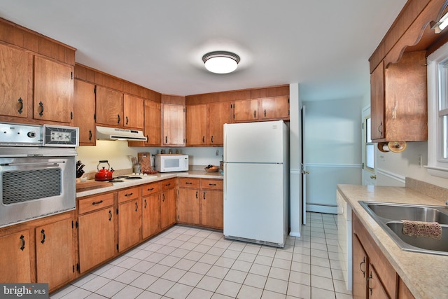 kitchen featuring white appliances, light tile patterned floors, sink, and a baseboard heating unit