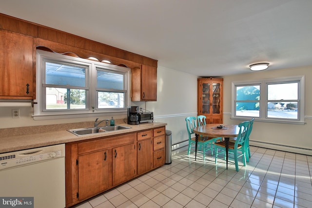 kitchen with sink, light tile patterned floors, dishwasher, and a baseboard heating unit