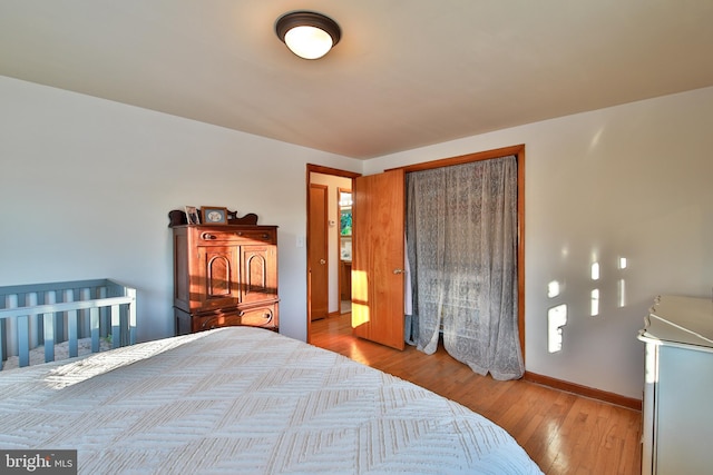 bedroom with light hardwood / wood-style floors and a closet