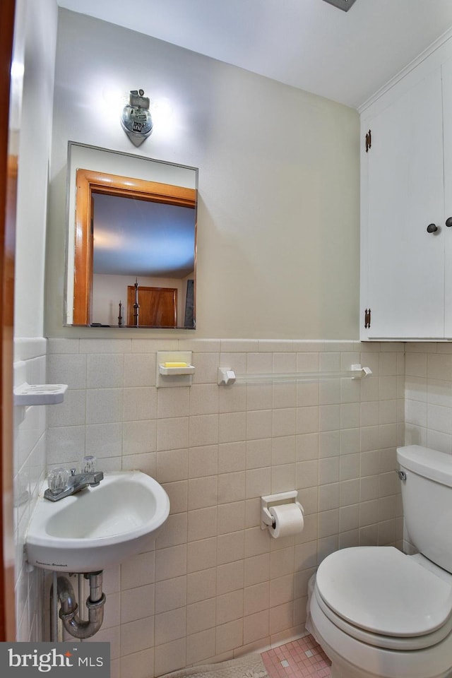 bathroom with tile walls, sink, tile patterned floors, and toilet