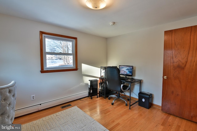 office space with a baseboard radiator, radiator, and light wood-type flooring