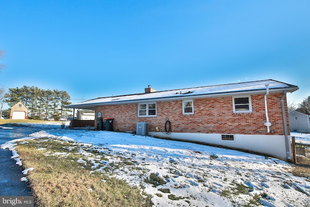 snow covered back of property with central air condition unit