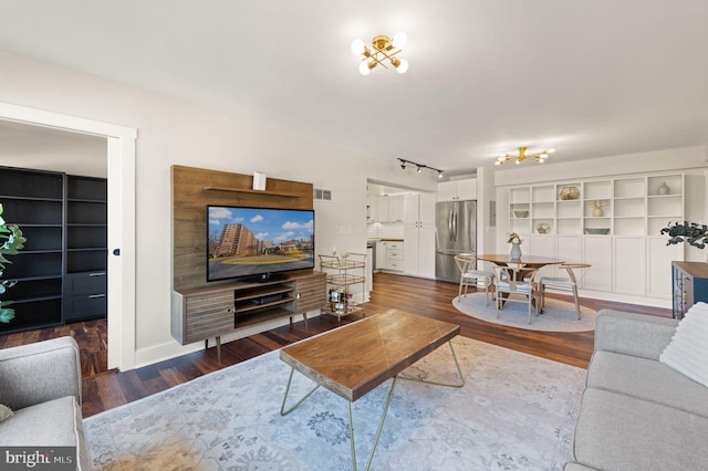 living room featuring dark hardwood / wood-style flooring and rail lighting