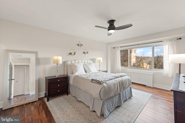 bedroom with ceiling fan, wood-type flooring, and radiator