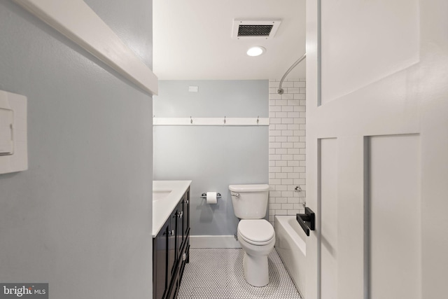 full bathroom featuring tile patterned flooring, vanity, tiled shower / bath, and toilet