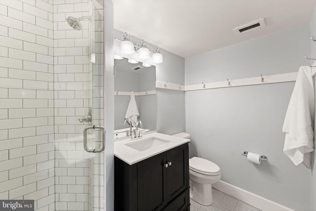 bathroom with tile patterned floors, vanity, toilet, and an enclosed shower