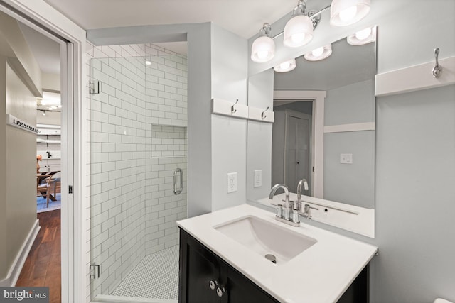 bathroom featuring an enclosed shower, vanity, and hardwood / wood-style flooring