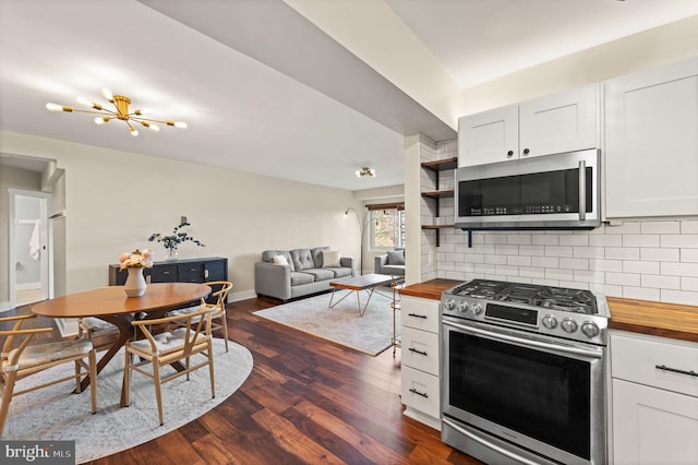 kitchen with tasteful backsplash, stainless steel appliances, butcher block countertops, and white cabinets