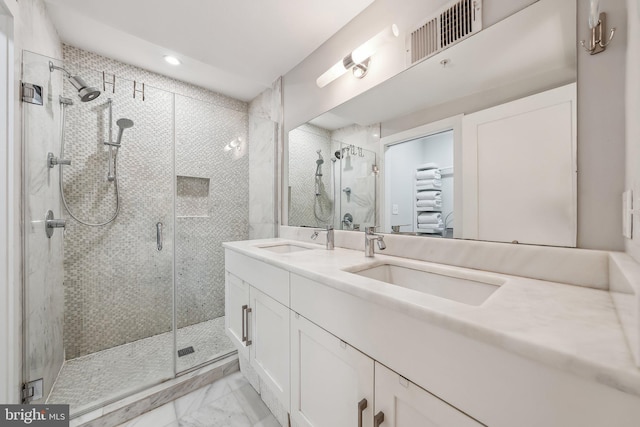 bathroom featuring marble finish floor, visible vents, a sink, and double vanity