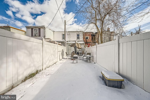 222 S Carey St, Baltimore, MD 21223 - snow covered patio featuring a fenced backyard, a patio, and a residential view