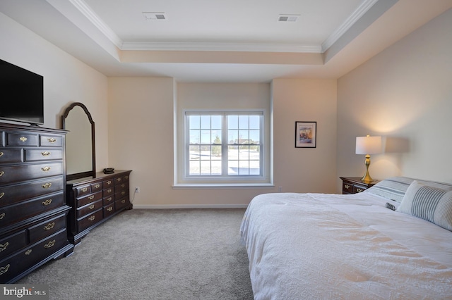 carpeted bedroom with ornamental molding and a tray ceiling