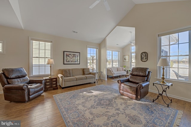 living room with ceiling fan, wood-type flooring, and lofted ceiling