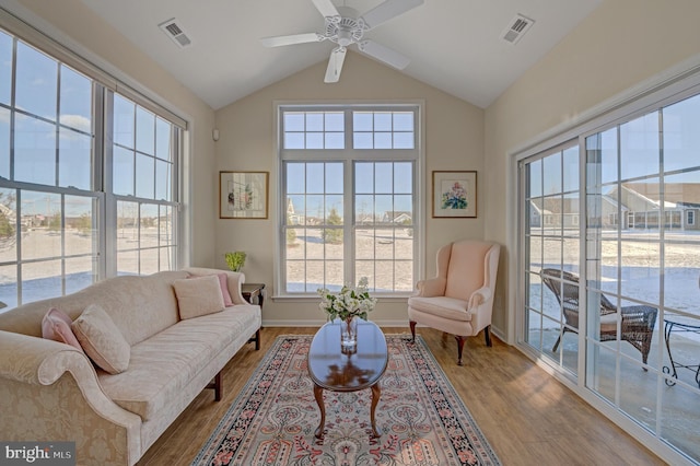 living room with hardwood / wood-style floors, vaulted ceiling, and ceiling fan