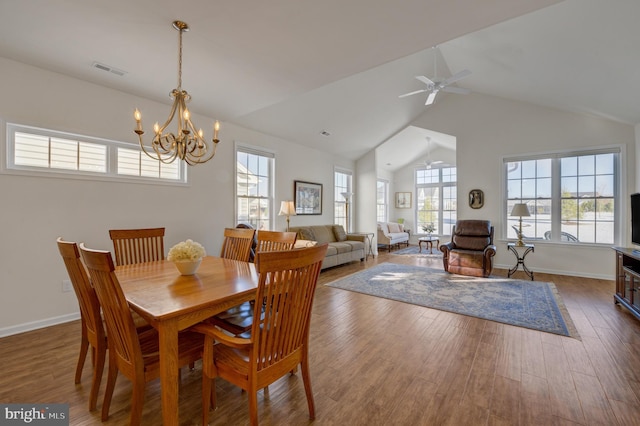 dining area with ceiling fan with notable chandelier, dark hardwood / wood-style flooring, and lofted ceiling