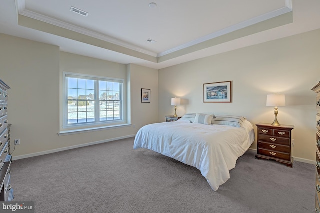 bedroom with carpet floors, a tray ceiling, and ornamental molding