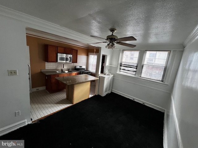 kitchen with kitchen peninsula, appliances with stainless steel finishes, backsplash, ceiling fan, and sink