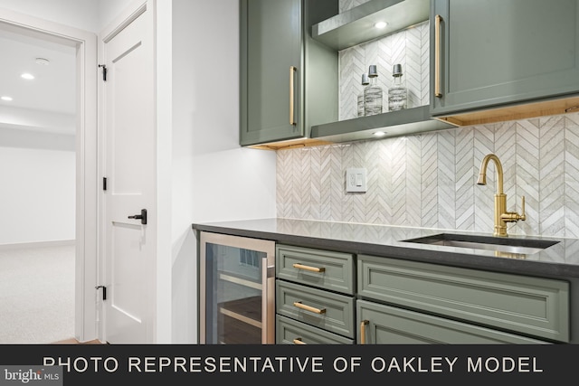 kitchen featuring sink, green cabinets, decorative backsplash, and wine cooler