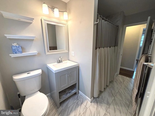 bathroom featuring vanity, curtained shower, and toilet