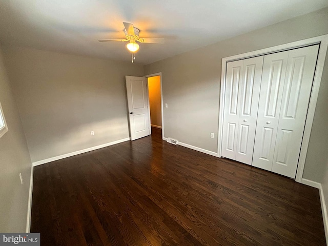 unfurnished bedroom featuring ceiling fan, dark wood-type flooring, and a closet