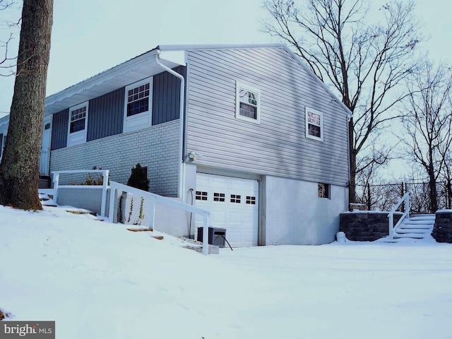 snow covered property featuring a garage