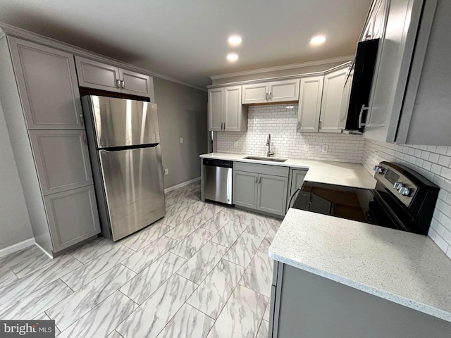 kitchen featuring sink, light stone counters, gray cabinets, appliances with stainless steel finishes, and ornamental molding