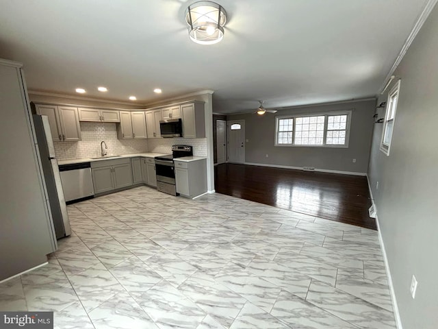 kitchen with gray cabinetry, sink, ceiling fan, ornamental molding, and appliances with stainless steel finishes