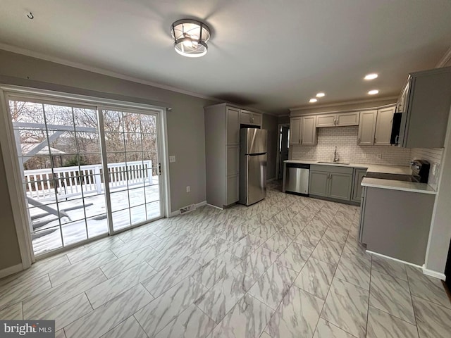 kitchen featuring backsplash, gray cabinets, sink, and appliances with stainless steel finishes