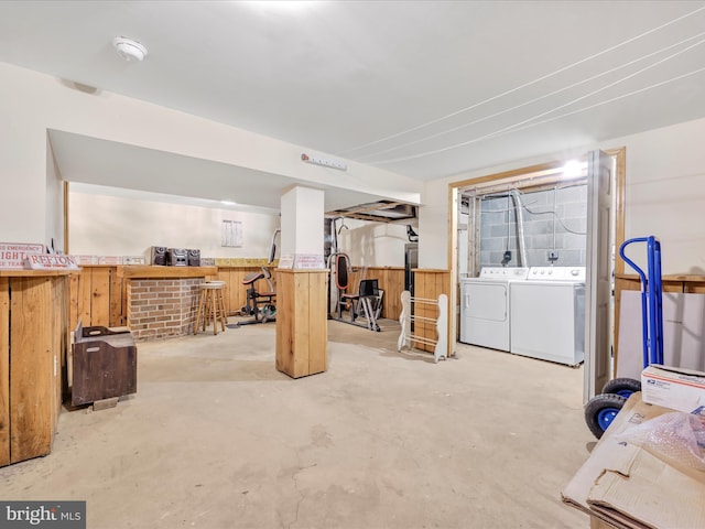 basement with separate washer and dryer and wood walls