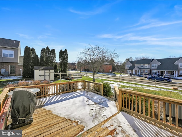 wooden deck with central AC unit and a storage unit