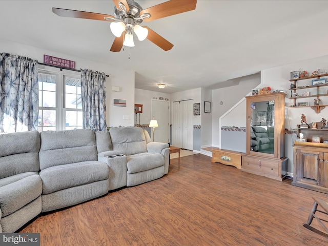 living room featuring ceiling fan and dark wood-type flooring