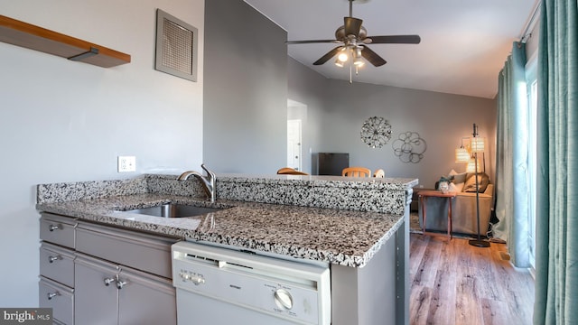 kitchen featuring dishwasher, stone countertops, ceiling fan, and sink