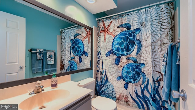 bathroom featuring vanity, toilet, and curtained shower