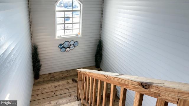 staircase featuring wooden walls