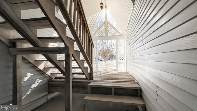 stairway featuring wood walls