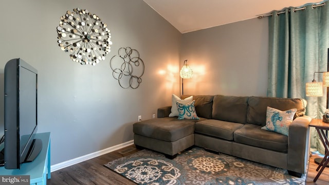 living room featuring lofted ceiling and dark wood-type flooring