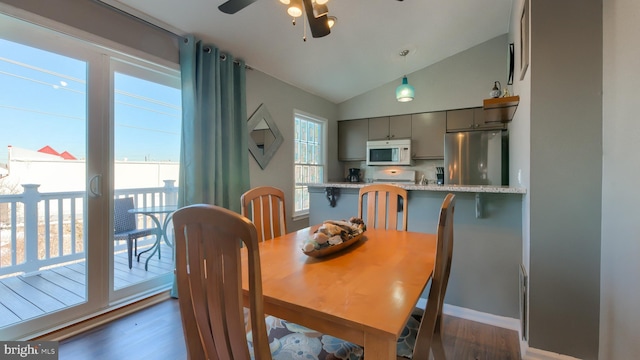 dining space with plenty of natural light, lofted ceiling, and dark wood-type flooring